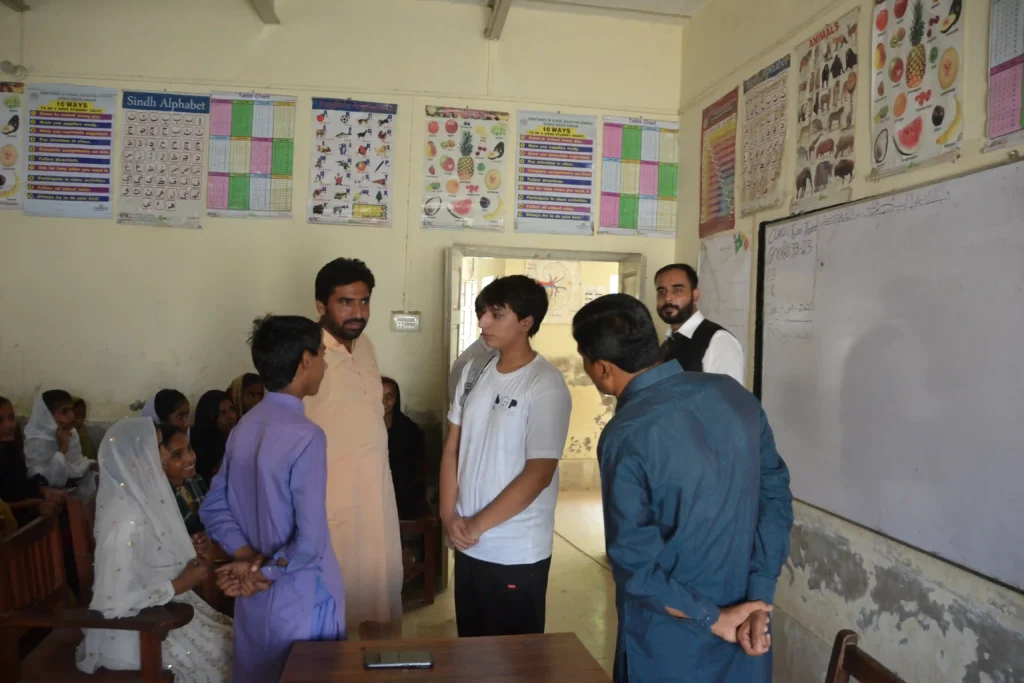 Student in rural Sindh talking with a visitor, expressing hopes for education
