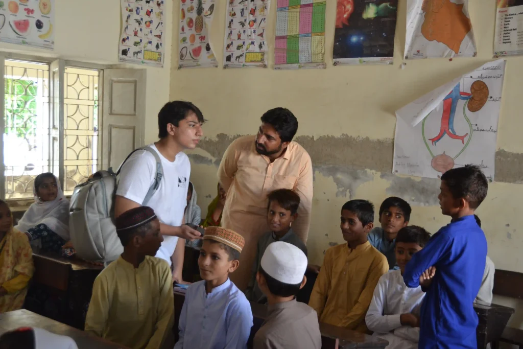 Children gathered outdoors, depicting the educational gap between urban and rural areas of Pakistan