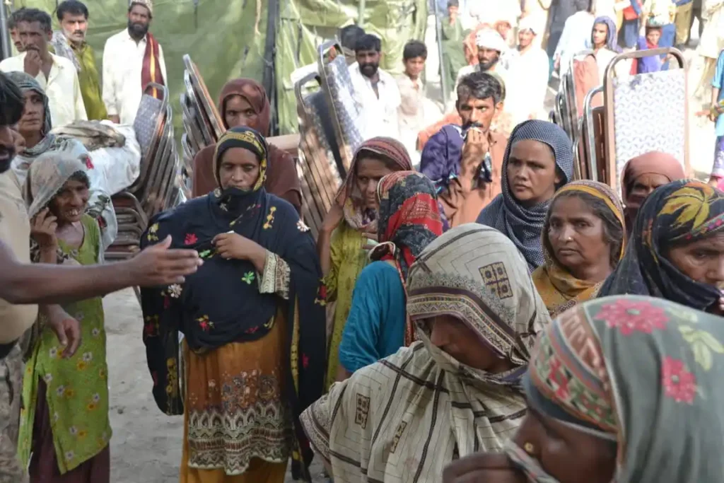Women queue patiently for vital aid during Muzaffargarh flood relief efforts.