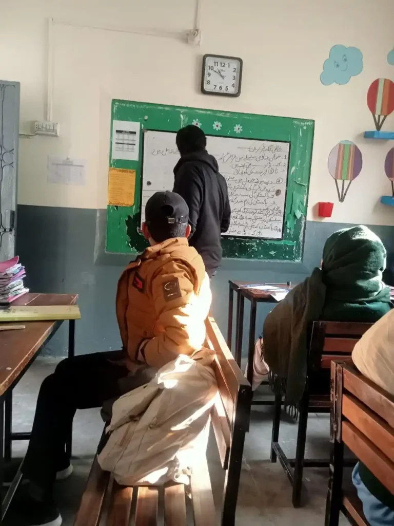 TCF students engaged in learning AI concepts with Yahya Amir in a classroom setting in Pakistan.