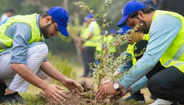 Pakistani youth engaged in planting trees as part of a local environmental conservation project, symbolizing commitment to a greener Pakistan and climate resilience.